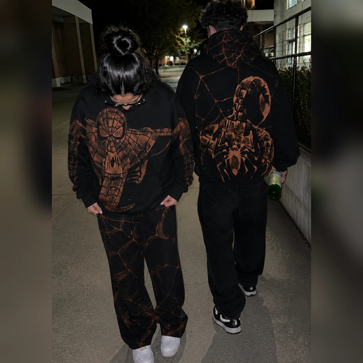 Two people wearing the hoodies outside at night